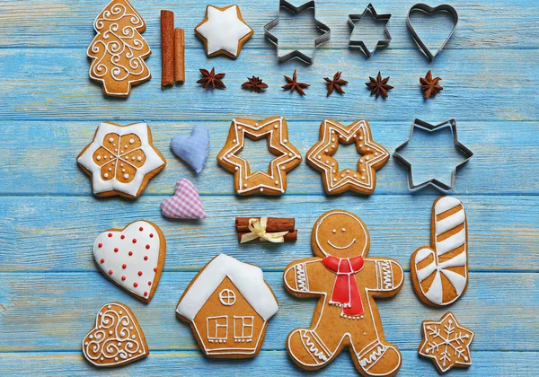 Délicieux biscuits de Noël avec des coupeurs sur fond en bois — Photo