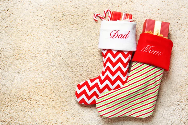 Cute Christmas stockings on beige textured background — Stock Photo, Image