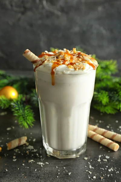 Delicious milkshake with Christmas decoration on grey textured background — Stock Photo, Image