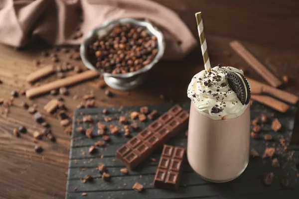 Delicioso batido cremoso con galleta sobre fondo de madera —  Fotos de Stock