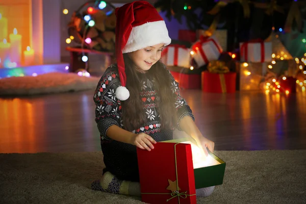 Küçük kız Noel hediyesi oturma odasında açılış — Stok fotoğraf