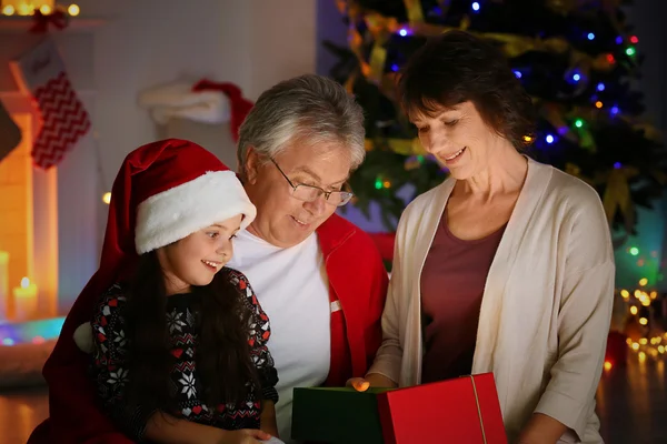 Liten flicka öppnar julklapp från hennes morföräldrar — Stockfoto