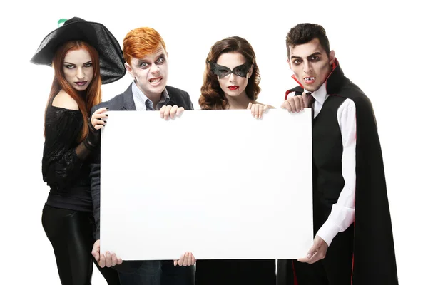 Young people in Halloween costumes holding paper board, isolated on white — Stock fotografie