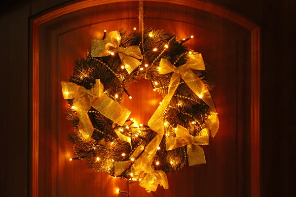 Bela grinalda de Natal com guirlanda na porta — Fotografia de Stock