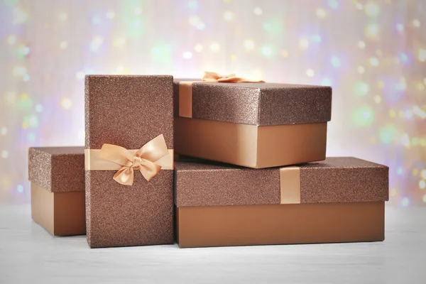 Boxes with Christmas presents on wooden surface against defocused lights — Stock Photo, Image