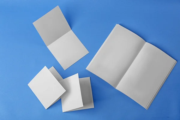Brochura em branco e brochuras sobre fundo azul — Fotografia de Stock