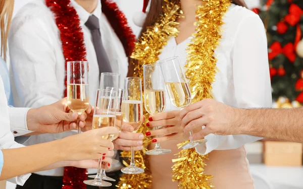 Young people with glasses of champagne celebrating Christmas at corporate party, close up view — Stock Photo, Image