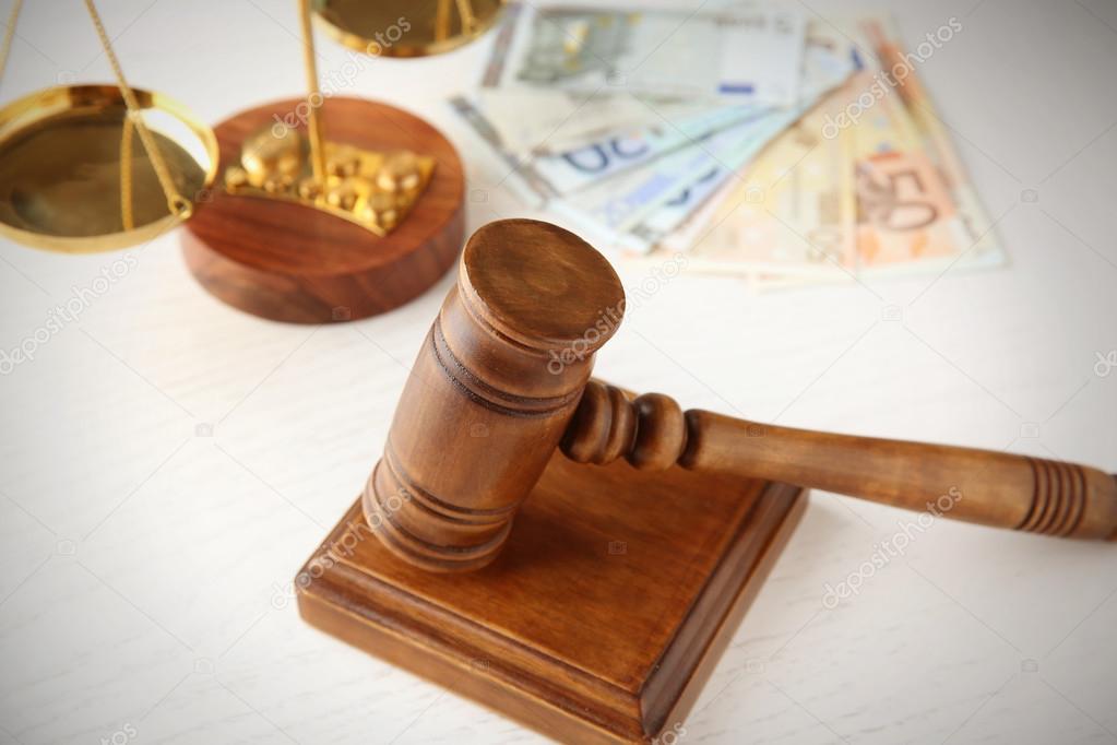 Gavel and scales on white table