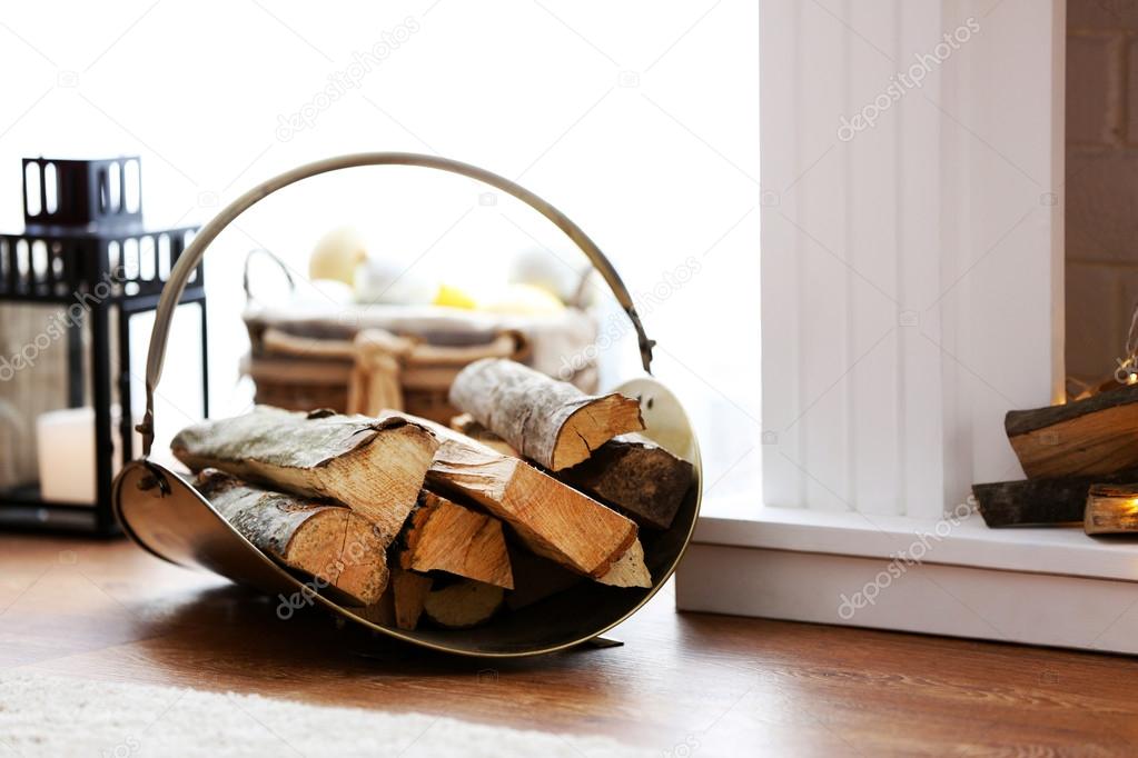 Logs near decorative Christmas fireplace, closeup