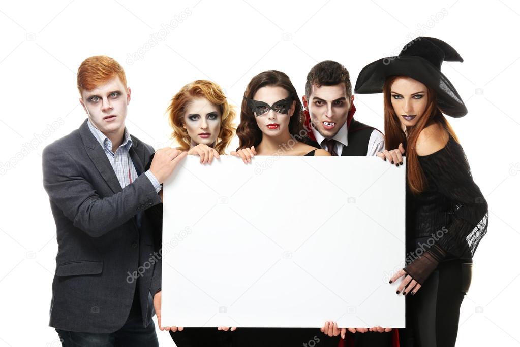 Young people in Halloween costumes holding paper board, isolated on white
