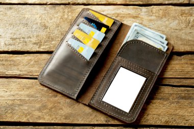 Ahşap arka plan üzerine açık kahverengi deri çanta