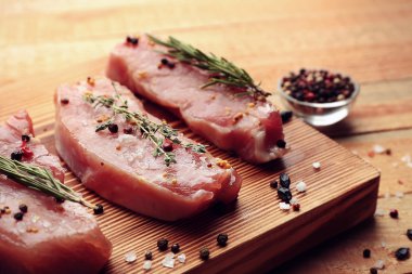 Otlar ve baharatlar ahşap kesme tahtası üzerinde çiğ biftek