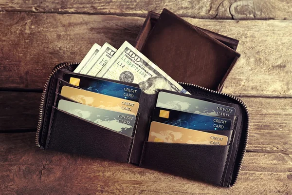 Ahşap arka plan üzerinde para ile deri cüzdan — Stok fotoğraf