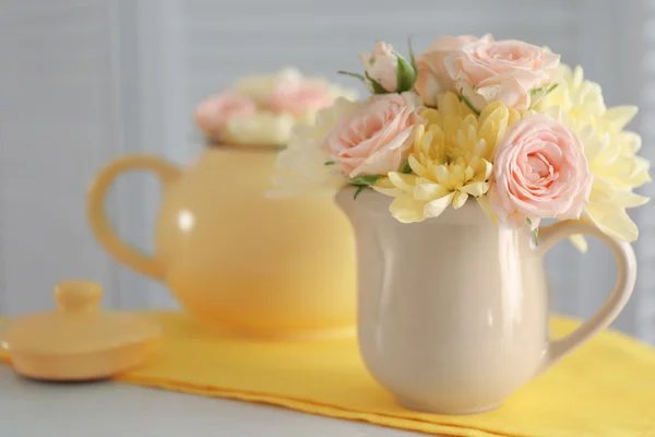 Bukett med vackra blommor i kannan på gula servett — Stockfoto