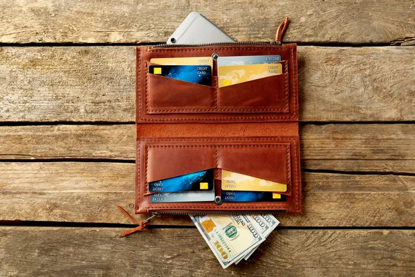 Nyitott barna bőr pénztárca, fából készült háttér — Stock Fotó