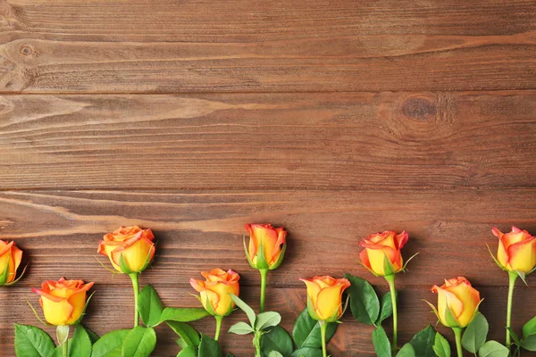 Moldura de rosas frescas no fundo de madeira — Fotografia de Stock