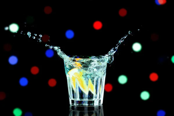 Colorful cocktail with splash on blurred lights background — Stock Photo, Image