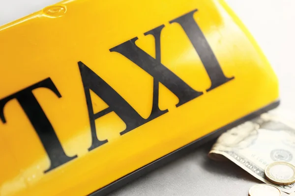 Žluté taxi střešní znamení s penězi, closeup — Stock fotografie