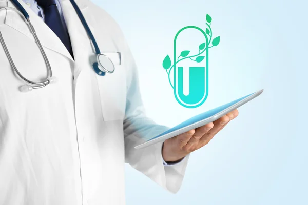 Dokter hand met tablet met projectie van de pil. Concept van de alternatieve geneeskunde. — Stockfoto