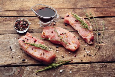 Otlar ve baharatlar ahşap arka plan üzerinde çiğ biftek