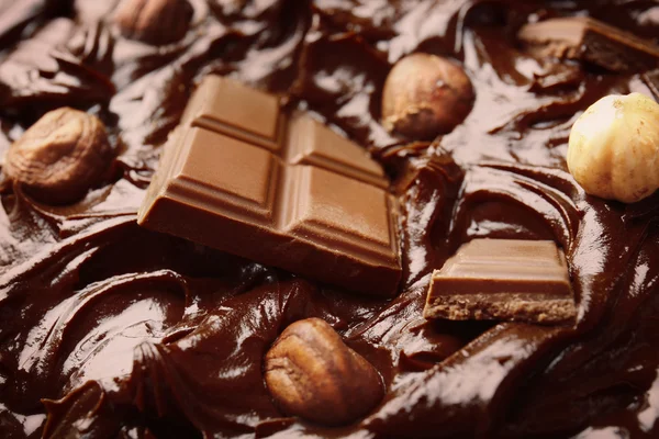 Delicioso chocolate derretido con trozos y nueces, primer plano — Foto de Stock