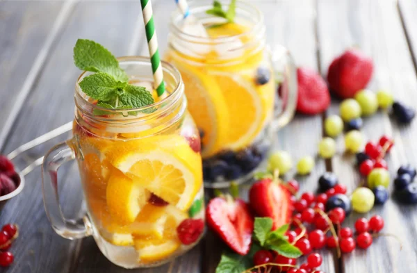 Refreshing water with fruits on table — Stock Photo, Image