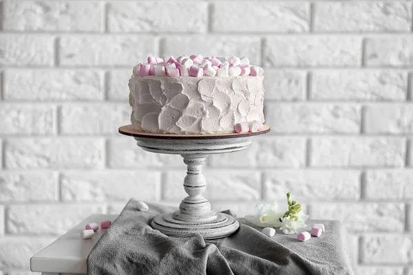 Bolo delicioso com marshmallows no fundo da parede de tijolo — Fotografia de Stock