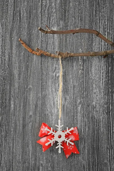 Christmas decor hanging on branch against grey wooden background — Stock Photo, Image