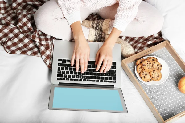 Dizüstü bilgisayar ve gıda kanepede rahatlatıcı ile kız — Stok fotoğraf