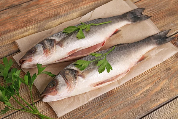 Pesce fresco con prezzemolo su fondo di legno — Foto Stock