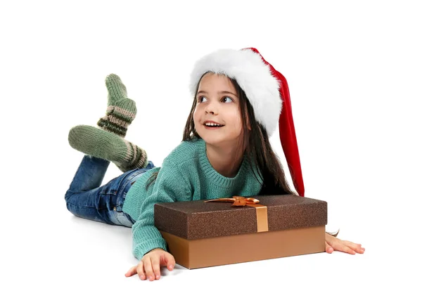 Menina bonito em chapéu de Santa com presente de Natal no fundo branco — Fotografia de Stock