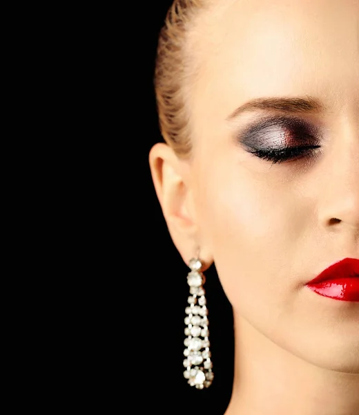 Retrato de una hermosa mujer joven con pendientes de moda sobre fondo negro —  Fotos de Stock