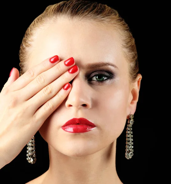 Portrait of beautiful young woman closing eye with hand, on black background — Stock Photo, Image