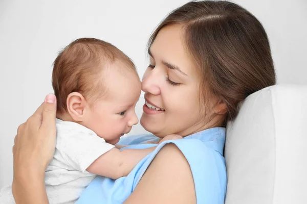 Retrato de una mujer joven sosteniendo a su bebé, vista de cerca — Foto de Stock