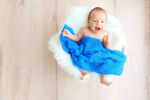 Carino bambino sdraiato su un plaid bianco soffice e coperto di coperta blu — Foto Stock