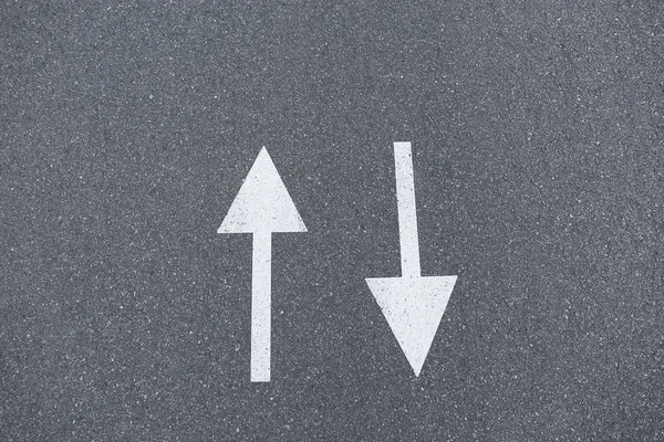 Arrow signs on asphalt road showing direction of movement, close up — Stock Photo, Image