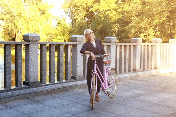 Mujer caminando con bicicleta — Foto de Stock