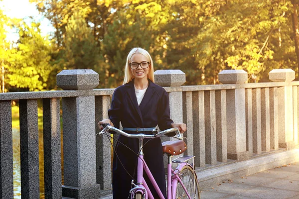 Kvinnan promenader med cykel — Stockfoto
