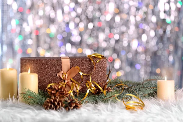 Рождественская композиция с подарочной коробкой, свечами и украшениями на боке фоне — стоковое фото