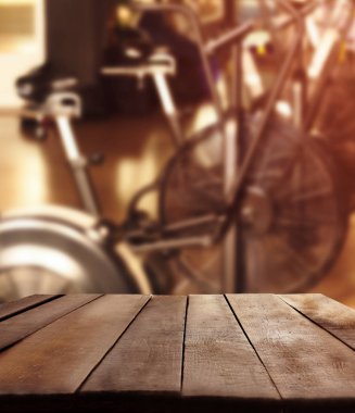 Ahşap masa bulanık spor salonu iç arka plan karşı. Spor ve sağlık kavramı.