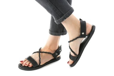 Siyah deri sandalet üzerine beyaz izole kadın ayakları üzerinde