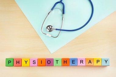 Ahşap arka plan üzerinde sağlık stetoskop ve word Fizyoterapi