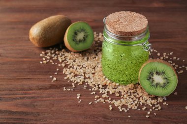 Vücut fırçalayın ve kivi ahşap arka plan üzerinde