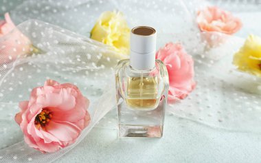 Parfüm şişesi ve açık renkli çiçekler