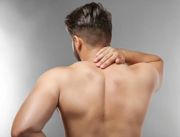 Hombre con dolor de cuello sobre fondo gris —  Fotos de Stock