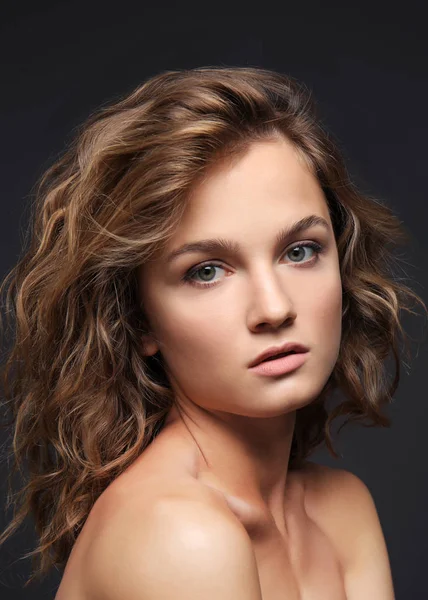 Portrait of beautiful young woman with long hair on grey background — Stock Photo, Image