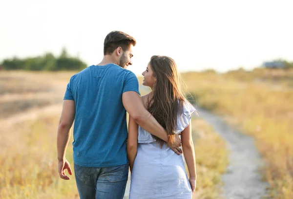 Jeune couple amoureux étreignant au coucher du soleil — Photo