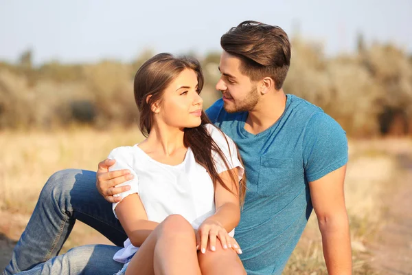 牧草地で一緒に座って美しい若いカップル — ストック写真