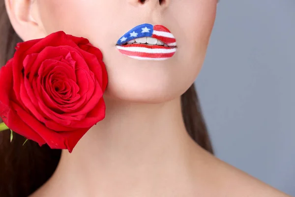 Fille avec USA maquillage et rose rouge sur fond gris — Photo