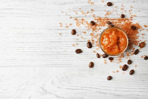 Body scrub, coffee beans on wooden background